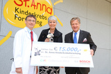 Wolfgang Holter (Institutsleiter der St. Anna Kinderkrebsforschung) nimmt den Spendenscheck von Renate Weiss (Bosch Brand-Marketing) und Peter Henner (Geschäftsleiter Bosch) entgegen.