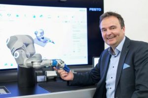 Rainer Ostermann, Country Manager von Festo Österreich, mit dem BionicCobot. (©Festo)
