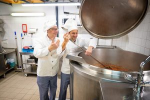 Drei CEO Rudolf Schrefl und Caritasdirektor Klaus Schwertner kochen gemeinsam den ersten Minestrone-Suppenkessel im Rahmen der Drei Hilft-Winteraktion.